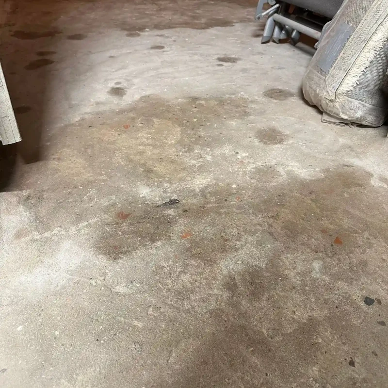 Verschmutzter Betonboden in Garage mit Flecken und Feuchtigkeitsschäden